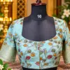 embroidered aqua blouse on mannequin