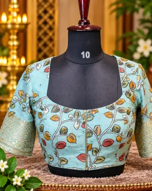 embroidered aqua blouse on mannequin